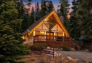 Eine Lodge mit Holzbauweise, einem Balkon und einer Treppe, die zum Eingang führt.