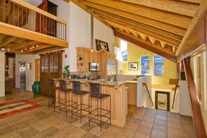 A spacious kitchen with a wooden ceiling, a bar area, and a view of the city through large windows. - Downtown Penthouse - Walk to Gondola & Casinos (South Lake Tahoe)