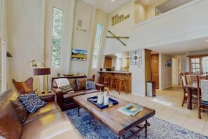 Ein geräumiges Wohnzimmer mit Sofa, Couchtisch und Blick auf die Küche und den Essbereich.