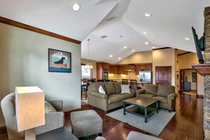 A spacious living area with a fireplace, a dining area, and a kitchen in the background. - Ideally Located Condo - 6-min Walk to Casinos (South Lake Tahoe)