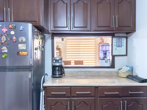 A kitchen with wooden cabinets, a stainless steel refrigerator, a coffee maker, and a water dispenser. - Amplia Casa Familiar con Parking (Monterrey)