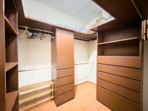 A walk-in closet with wooden shelving and a metal rack. - Amplia Casa Familiar con Parking (Monterrey)