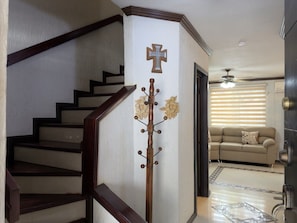 A staircase with a wooden handrail and a wall-mounted coat rack with a cross and decorative elements. - Casa grande cerca del BBVA (Monterrey)