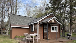A small lodge with a dining area, a grill, and a sign indicating a campground. - Copper Ridge at Miller's Cottages (Ontonagon)