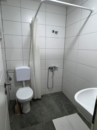 A small, modern bathroom with a toilet, shower, and sink.. Guesthouse Cologne North For business travelers, tourists & families