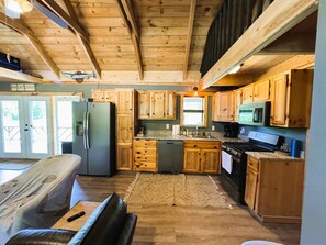 Une cuisine avec des meubles de rangement en bois, un réfrigérateur, une cuisinière et un four à micro-ondes.