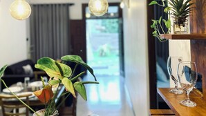A dining area with wooden tables, hanging rope lights, and potted plants. - Peaceful private villa just steps from the beach in Habaraduwa (Habaraduwa)