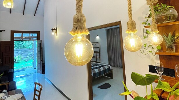 A modern interior with a dining area, a staircase, and a view into another room. - Peaceful private villa just steps from the beach in Habaraduwa (Habaraduwa)