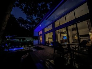 A modern building with large windows, a deck, and outdoor seating. - Dreamers’ Refuge (adults only, private pool) (Provincia de Puntarenas)