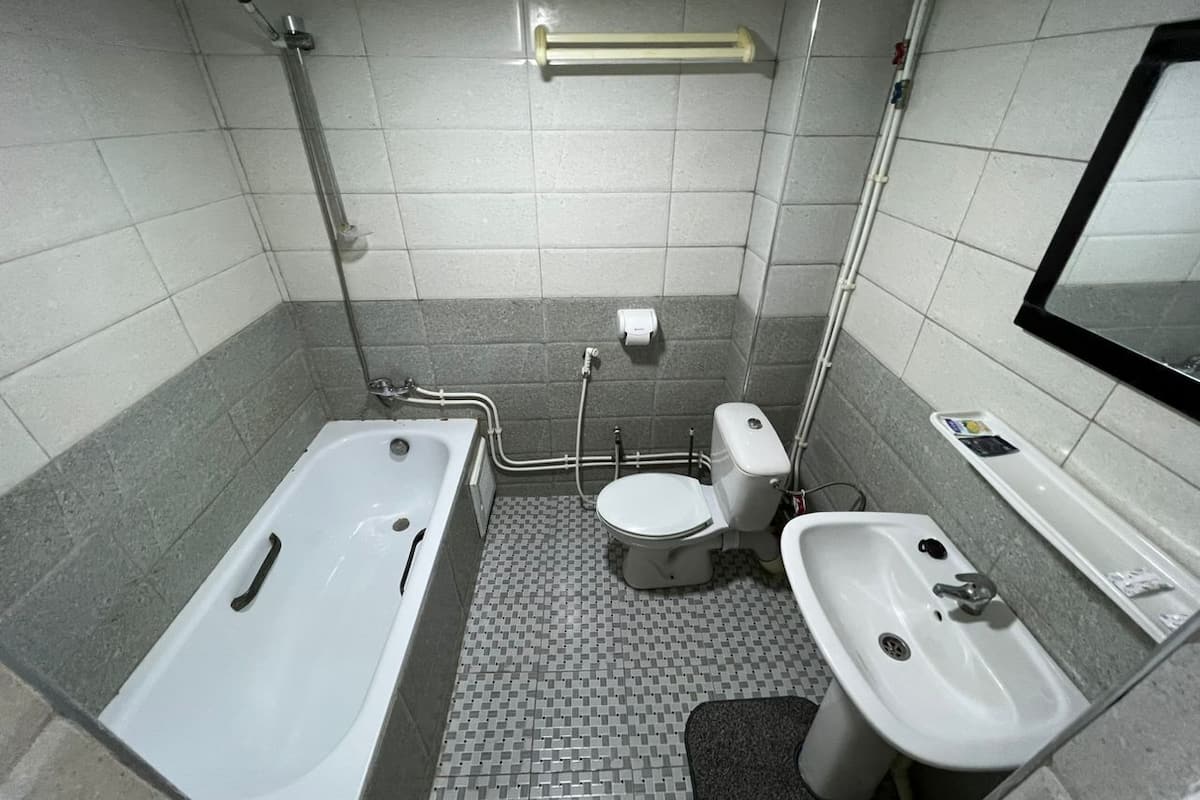 A bathroom with a bathtub, toilet, and sink.