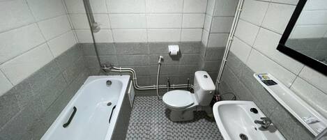 Un baño con bañera, inodoro y lavamanos.
