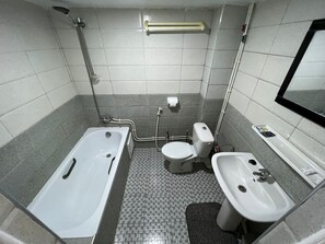 Un baño con bañera, inodoro y lavamanos.