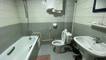 A bathroom with a bathtub, toilet, sink, and shower.