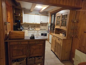 A kitchen with wooden cabinets, a stove, and a sink.
