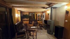 A cozy living room with a fireplace, wooden furniture, and a television. - Fully-equipped family chalet with large garden 300m from lifts. (Leysin)