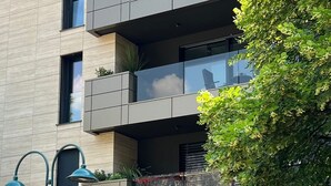 A modern multi-story building with balconies, a street lamp, and a sign reading 'Luxury Garden Life.'