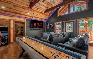 A cozy room with a pool table, a Netflix TV, and a lounge area with a view. - Amazing BRAND NEW 8bdrm Cabin-Pool-Arcades-Gazebo (Sevierville)