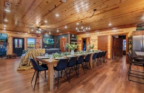 A wooden interior with a dining area, a sofa, and a fireplace. - Amazing BRAND NEW 8bdrm Cabin-Pool-Arcades-Gazebo (Sevierville)