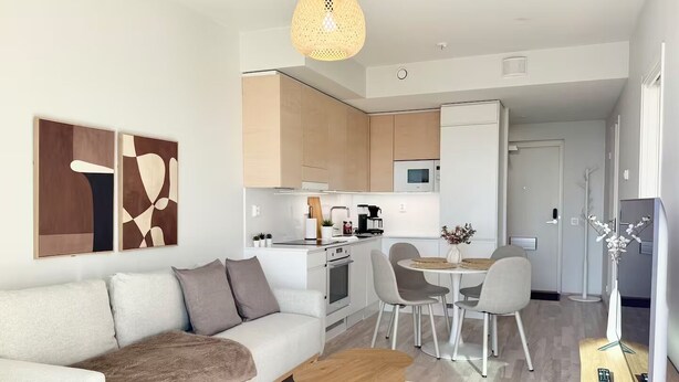 Un salon moderne avec un canapé, une table basse et un coin repas.