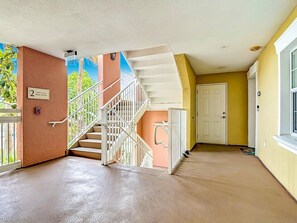 A multi-level interior with a staircase, a door, and a wall with a number sign. - Reunion Elegant Disney Condo, Resort Amenities (Kissimmee)