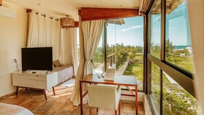 Ein Zimmer mit einem Bett, einem Fernseher, einem Tisch und Blick auf eine Landschaft.