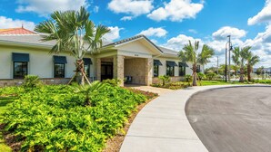 A building with a curved driveway, palm trees, and a clear blue sky. - SL4895 - 5BR house with private pool in Kissimmee (Kissimmee)