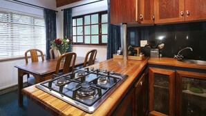 Una cocina con armarios de madera, una estufa a gas y un lavamanos.