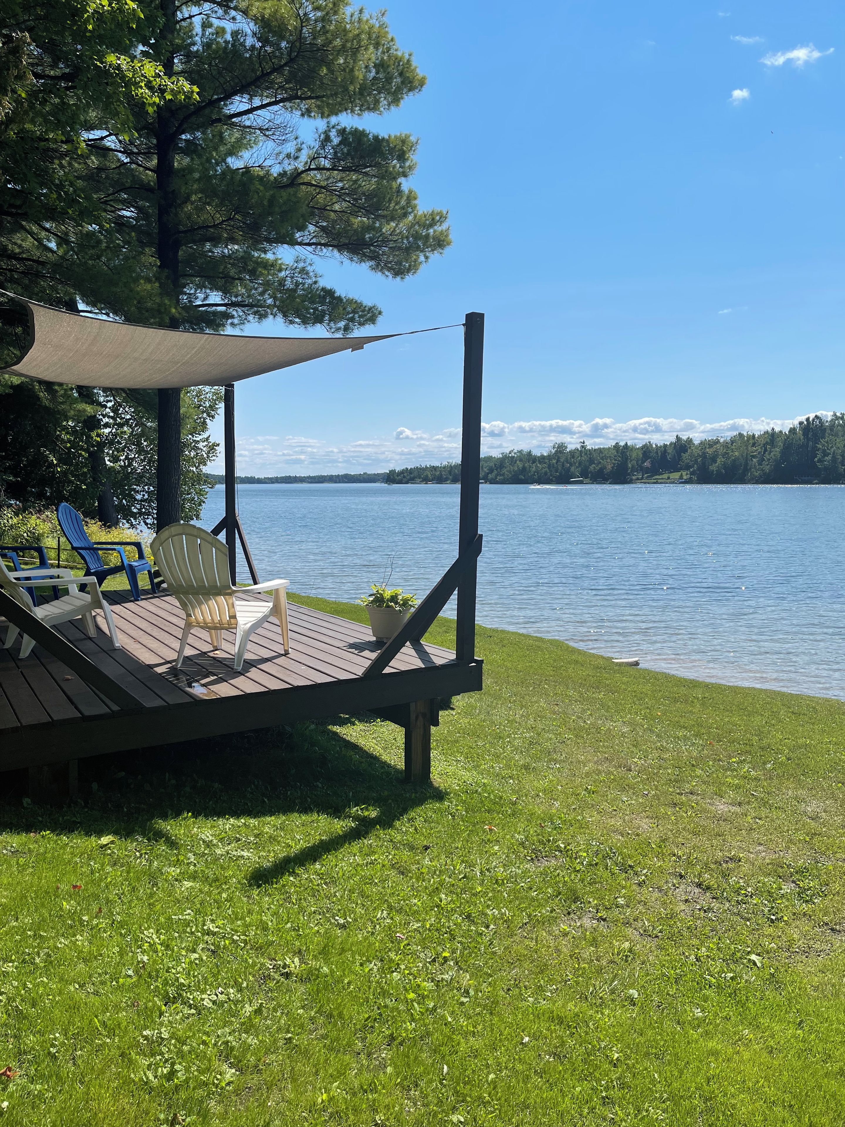 En terrass med utomhusmöbler och utsikt över en sjö.