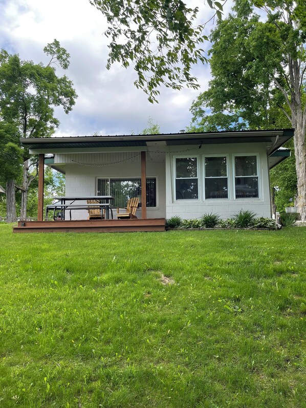 A house with a covered porch, a table, and chairs.