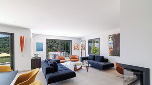 Ein modernes Wohnzimmer mit einer Sofagarnitur, einem Couchtisch und einem Fernseher.
