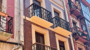 A multi-story building with balconies, a storefront, and visible signage. - MAGDALENA APARTMENT (Oviedo)