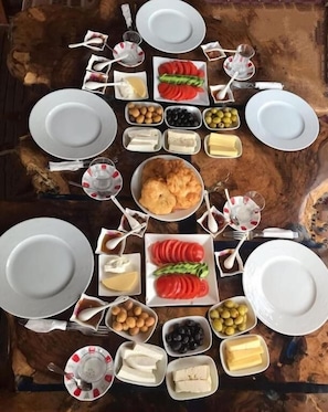 Una mesa con platos, tazones y diversos alimentos dispuestas para una comida.