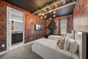 A bedroom with a brick wall, a bookshelf, a bed, and a TV. - 9Br Spacious Villa With Private Pool Close Disney (Kissimmee)