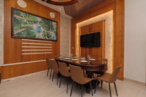 Un comedor con una mesa redonda, sillas, un cuadro y un televisor.