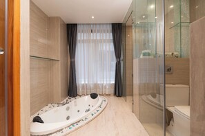 Un baño moderno con bañera independiente, cabina de ducha con paredes de vidrio y un inodoro.