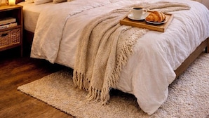 A bedroom with a large bed, a bedside table with a lamp, a hanging light fixture, a framed picture on the wall, and a closet with hanging clothes. - Praça do Comercio Romantic Apartment (Lisboa)