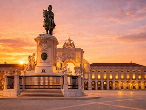 A grand architectural structure with a statue, ornate details, and a large building in the background. - Praça do Comercio Romantic Apartment (Lisboa)