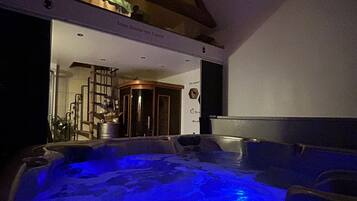 Un jacuzzi avec un éclairage bleu, un escalier et une pièce avec une porte.