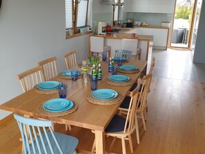 A dining area with a wooden table set for six, surrounded by matching chairs. - Villa Near Baltic Sea (2.5 km) – 4 Bedrooms, 3 Bathrooms, Private Garden (Łebcz)