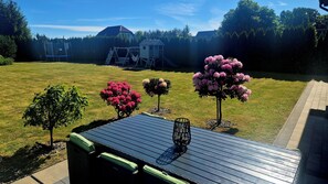 A backyard with a play structure, a small tree, and a patio table. - Villa Near Baltic Sea (2.5 km) – 4 Bedrooms, 3 Bathrooms, Private Garden (Łebcz)