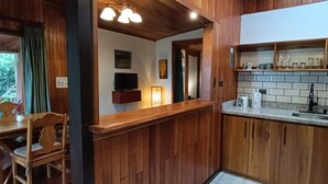 Interior em madeira com cozinha, incluindo bancada, pia e armários.