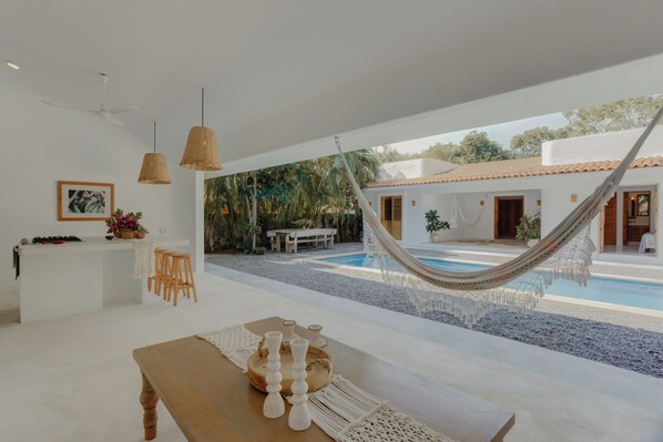 A modern interior with a pool, hammock, and outdoor seating area.