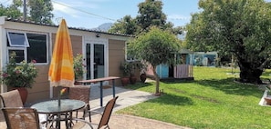A patio with outdoor furniture, a small table, and a yellow umbrella. - Room-joy's Place - Willy's Cottage - 2 S (Cape Town)