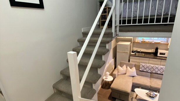 A staircase leading to a living area with a sofa and a coffee table.