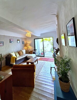 Un salon avec un canapé, une table basse, une lampe et une plante en pot.
