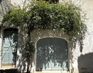 Un bâtiment doté d’une grande porte en arc de cercle et d’une plus petite porte, toutes deux fermées.