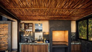 Una cocina moderna con techo de bambú, encimeras de mármol y horno empotrado.