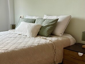 A neatly made bed with a quilted bedspread, a bedside table with a lamp, and a nightstand with a lamp. - * Coastal Paradise: Your relaxing corner by the beach (O Pindo)