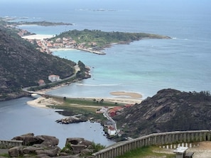 A coastal town with a bridge, rocky terrain, and a bay with clear waters. - * Coastal Paradise: Your relaxing corner by the beach (O Pindo)
