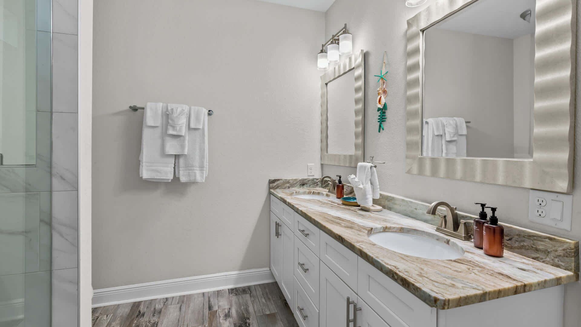 Une salle de bain avec deux lavabos, un grand miroir et un porte-serviettes.